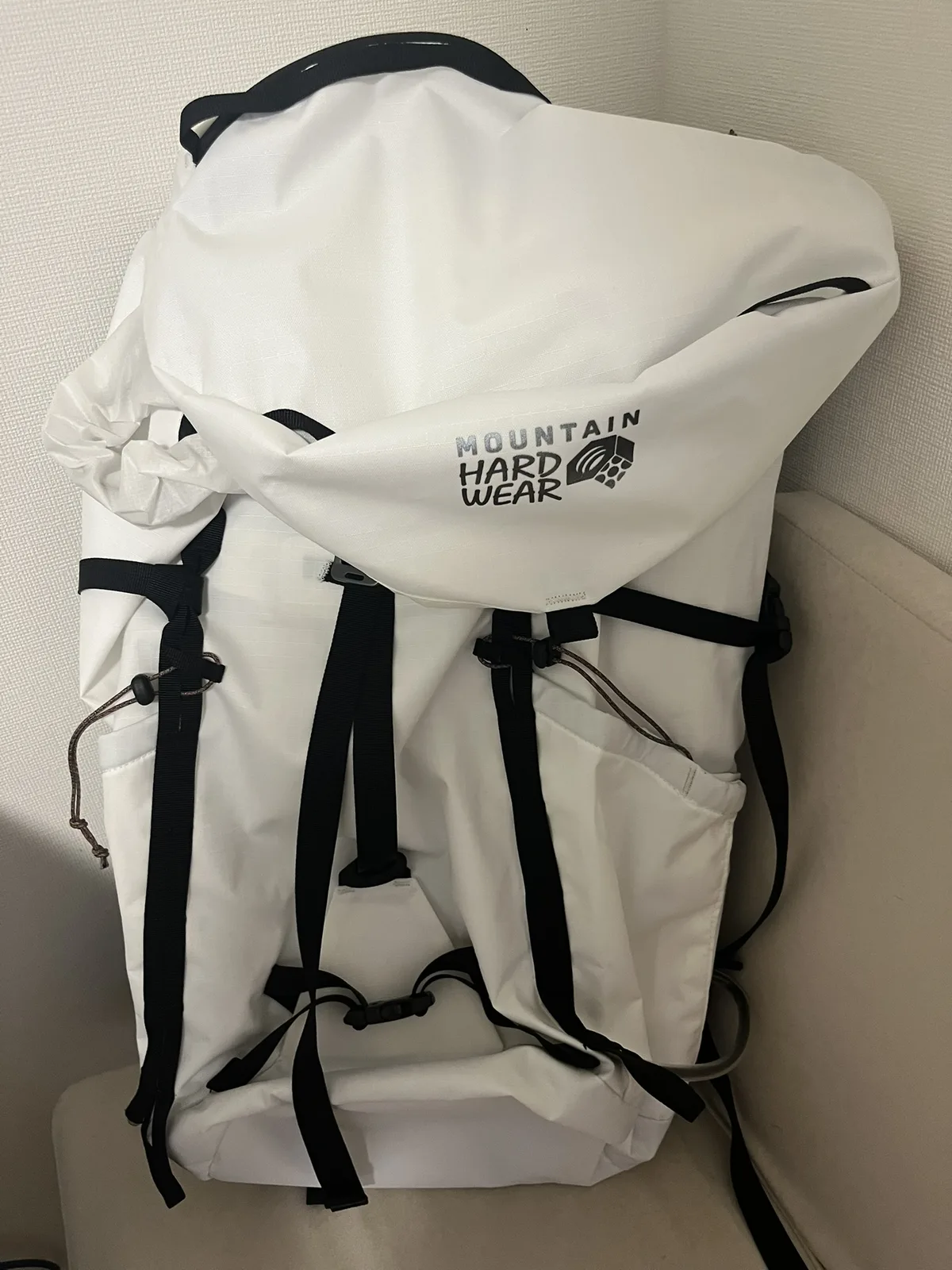 マウンテンハードウェア スクランブラー35（Undyed）の正面。白い生地に黒いストラップのロールトップ型バックパック
